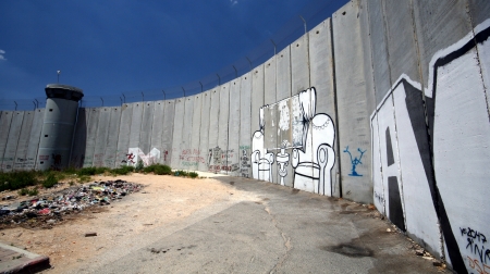 The Israeli separation wall juts into the Palestinian West Bank town of Bethlehem, along the border of Aida Refugee Camp, covered with graffiti by protesters of the barrier の写真素材
