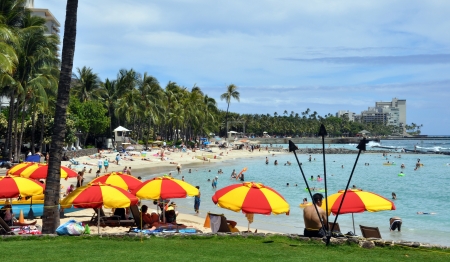 OAHU, HI - JUNE 22, 2013 - Tourist sunbathing and surfing on Waikiki beach June 22, 2013 in Oahu  Waikiki beach is beachfront neighborhood of Honolulu, best known for white sand and surfingのeditorial素材