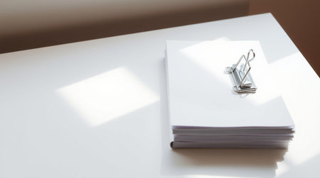 Paper clip and notebook on white table in office, business concept.の写真素材