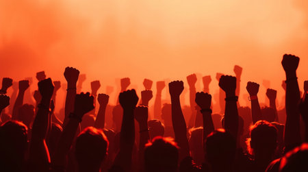Silhouettes of hands raised in the air at a music festival
