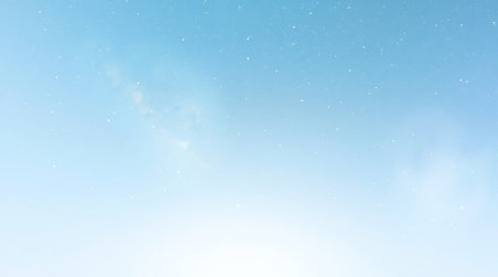 Falling snow on blue sky. Winter background with falling snowflakes