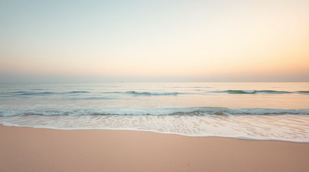 Soft wave of the sea on the sandy beach at sunrise time.