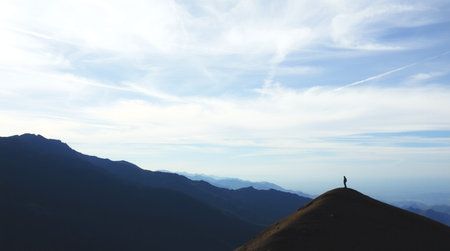 Silhouette of a man on top of a mountain in the morning