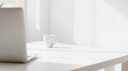 Laptop and coffee cup on white table in office, stock photo
