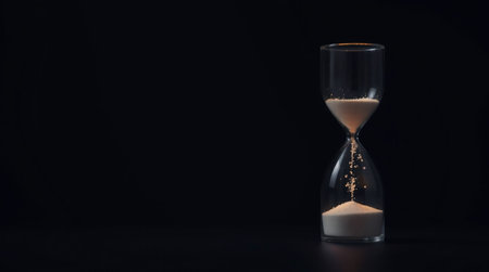 Hourglass with sand on black background. Concept of time passing.