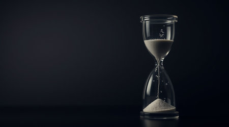 Hourglass on black background with copy space. Concept of time passing.