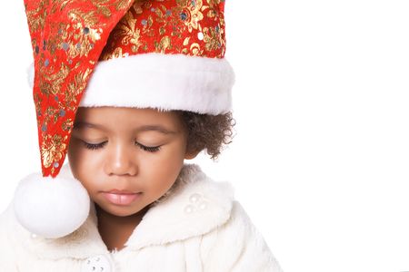 Portrait of a sweet baby in Christmas hat and fur on white backgroundの写真素材