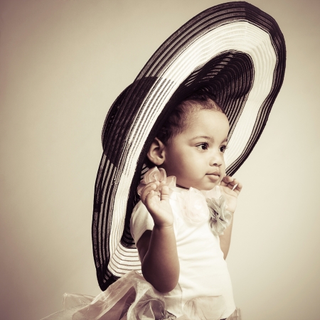 Portrait of a lovely little girl in a big fashionable hatの写真素材