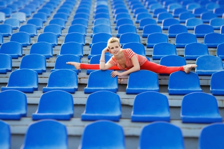 Beautiful sporty woman doing the splits on stadiumの写真素材