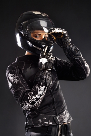 Beautiful woman in bikers outfit against black bacgroundの写真素材