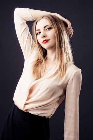 Beautiful woman in chiffon beige blouse against black background の写真素材