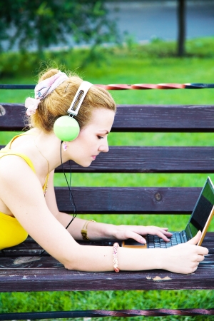 Young woman having rest in the park with laptop の写真素材
