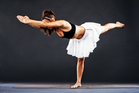Beautiful sporty woman is working out. Yoga asana. Virabhadrasana C, Warrior C.の写真素材
