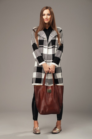 Elegant woman with a leather brown fashion bagの写真素材