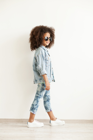 Beautiful stylish little girl in jean clothesの写真素材