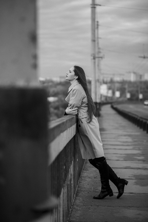 Beautiful woman on the bridge. Black and white picture with film grain imitation.の写真素材