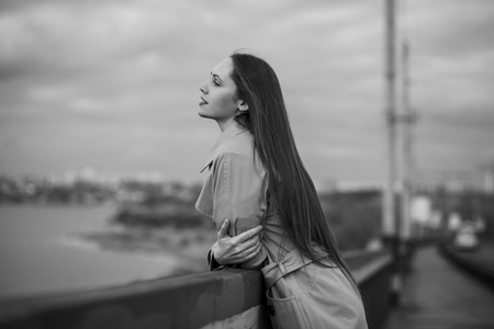 Beautiful woman on the bridge. Black and white picture with film grain imitation.の写真素材