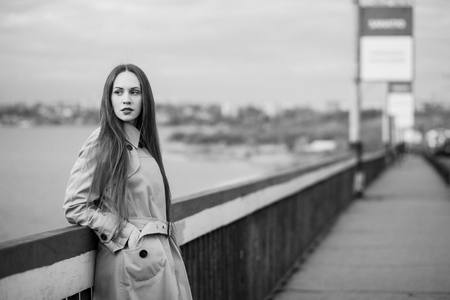 Beautiful woman on the bridge. Black and white picture with film grain imitation.の写真素材