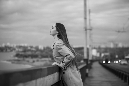 Beautiful woman on the bridge. Black and white picture with film grain imitation.の写真素材