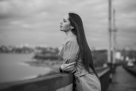 Beautiful woman on the bridge. Black and white picture with film grain imitation.の写真素材