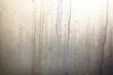 Rainy background with flowing down water drops on window glassの写真素材
