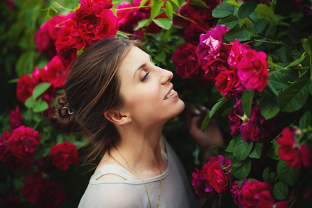 Portrait of a beautiful tender woman in rose gardenの写真素材