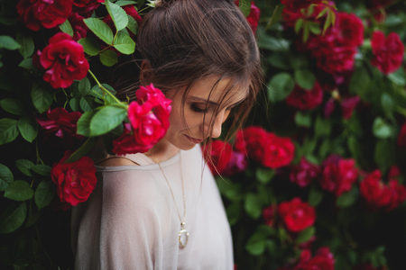 Portrait of a beautiful tender woman in rose gardenの写真素材