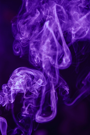 Beautiful ultra violet smoke against dark backgroundの写真素材