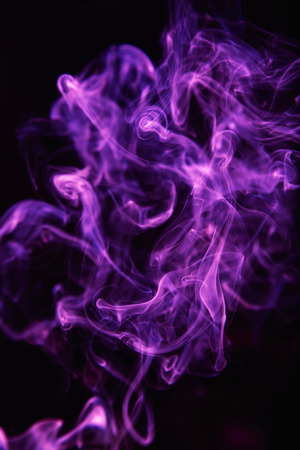 Beautiful ultra violet smoke against dark backgroundの写真素材