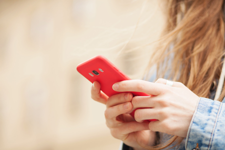 Closeup picture of female hands holding a smartphoneの写真素材