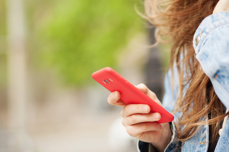 Closeup picture of female hands holding a smartphoneの写真素材