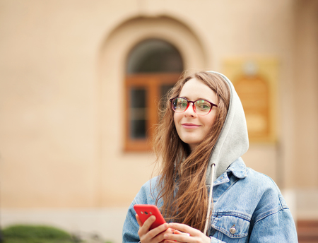 Outdoor picture of a young lovely woman with smartphoneの写真素材