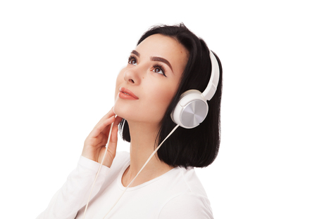 Young beautiful woman in headphones against white backgroundの写真素材