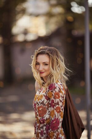 Outdoor portrait of beautiful woman in the autumn streetの写真素材