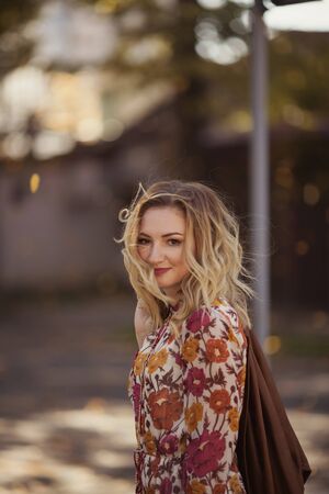 Outdoor portrait of beautiful woman in the autumn streetの写真素材