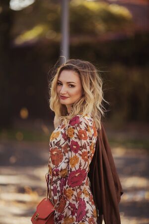 Outdoor portrait of beautiful woman in the autumn streetの写真素材