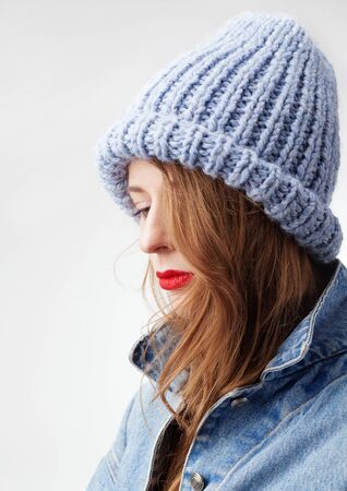 Beautiful woman in warm knit hat against white backgroundの写真素材