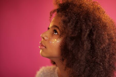 Cute girl with shiny makeup against bright pink backgroundの写真素材