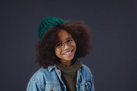 Cute smiley teenage girl against dark backgroundの写真素材