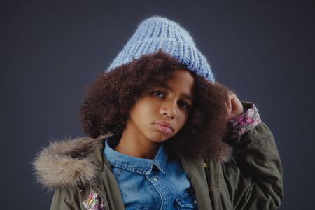 Studio portrait of lovely stylish teenage girl against dark backgroundの写真素材