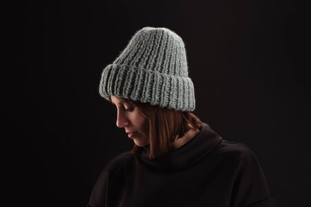 Lovely woman in warm knit hat against dark backgroundの写真素材