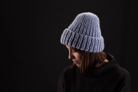 Lovely woman in warm knit hat against dark backgroundの写真素材