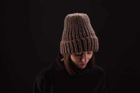 Lovely woman in warm knit hat against dark backgroundの写真素材
