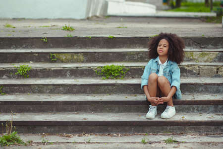Outdoor portrait of little girl sitting on stairsの写真素材
