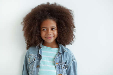 Cute stylish girl with beautiful curly hair in denim jacketの写真素材