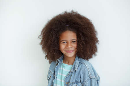 Cute stylish girl with beautiful curly hair in denim jacketの写真素材