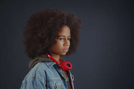 Portrait of serious teenage girl against dark background