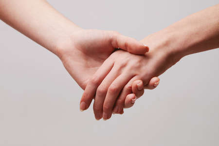 Two tender female hands are holding each otherの写真素材