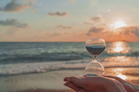Time is running fast. Hourglass in the hands symbolize the transience of time. Background is...
