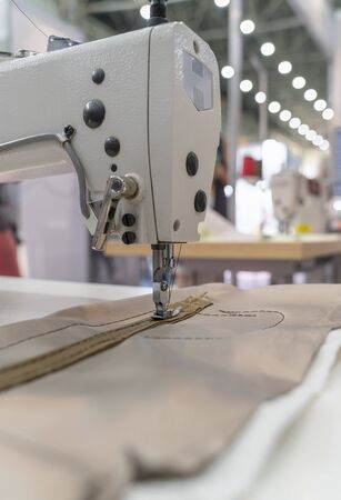 Clothes fabrication on a modern sewing machine. Vertical imageの写真素材